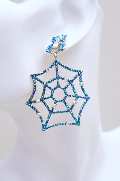 A single spiderweb-shaped drop earring with blue rhinestones and gold-tone metal, displayed on a white mannequin ear.